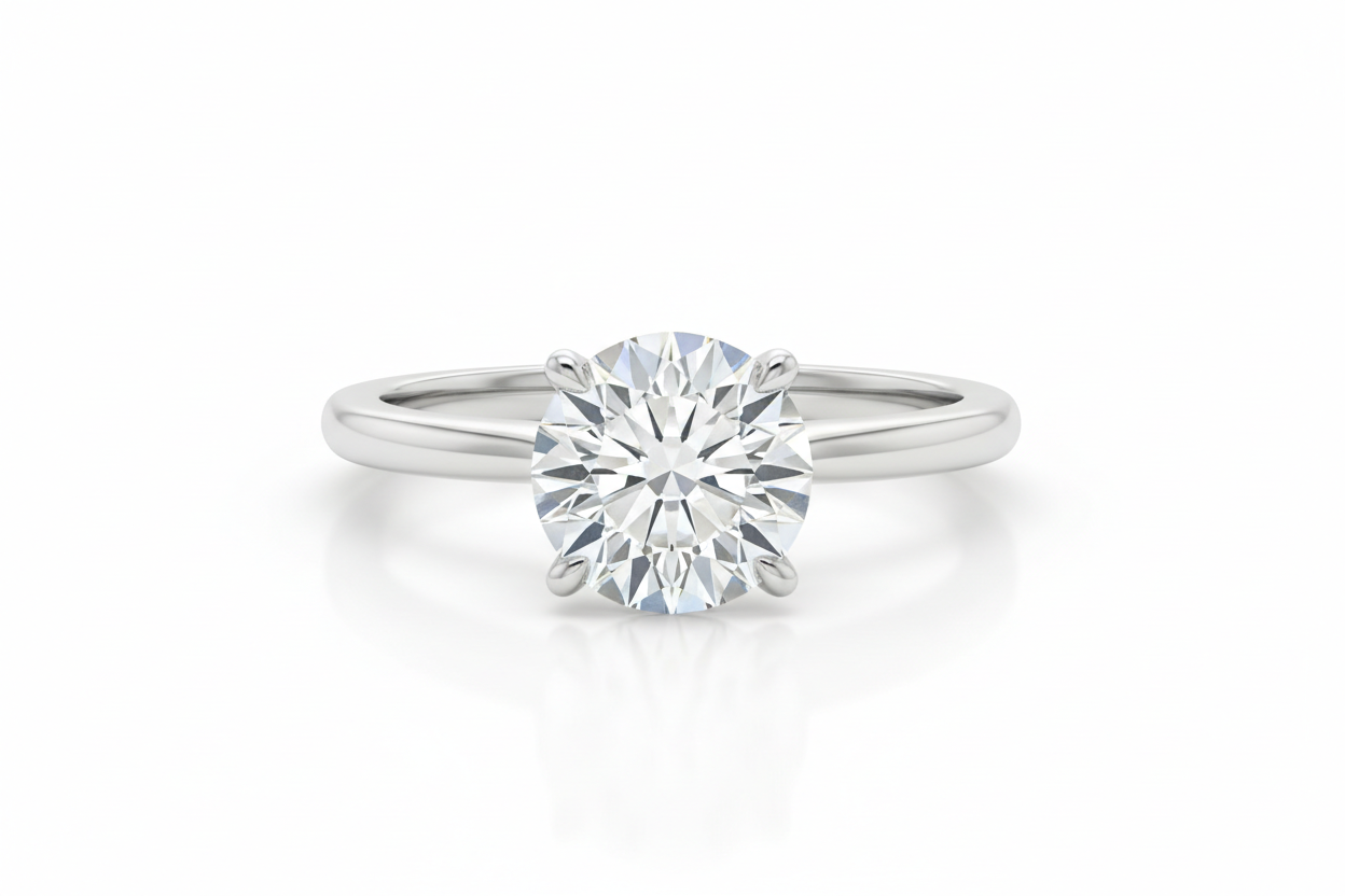 Ultra-realistic product photography of a 2-carat round brilliant diamond engagement ring, classic solitaire setting, four prongs, crafted in polished white gold. The diamond is perfectly centered, high clarity, excellent cut, sharp facets with natural light reflections. Professional jewelry product shot, studio lighting, soft shadows, crisp focus, photorealistic detail. Pure white background, luxury e-commerce style, high resolution, minimal, elegant, no props. the diamond is touching the bottom 